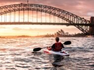 Hombre en la bahía de Sydney en un kayak de fondo el Harbour Bridge y la Opera House 
